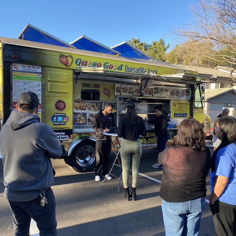 a group of people standing in front of a food truck a group of people standing in front of a food truck