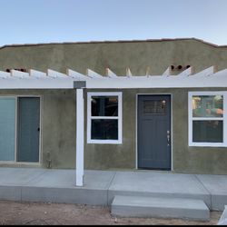JayBridge Construction - After: Exterior facelift from water damage, new pergola, window replacement, new concrete porch, new block walkway and custom stucco.