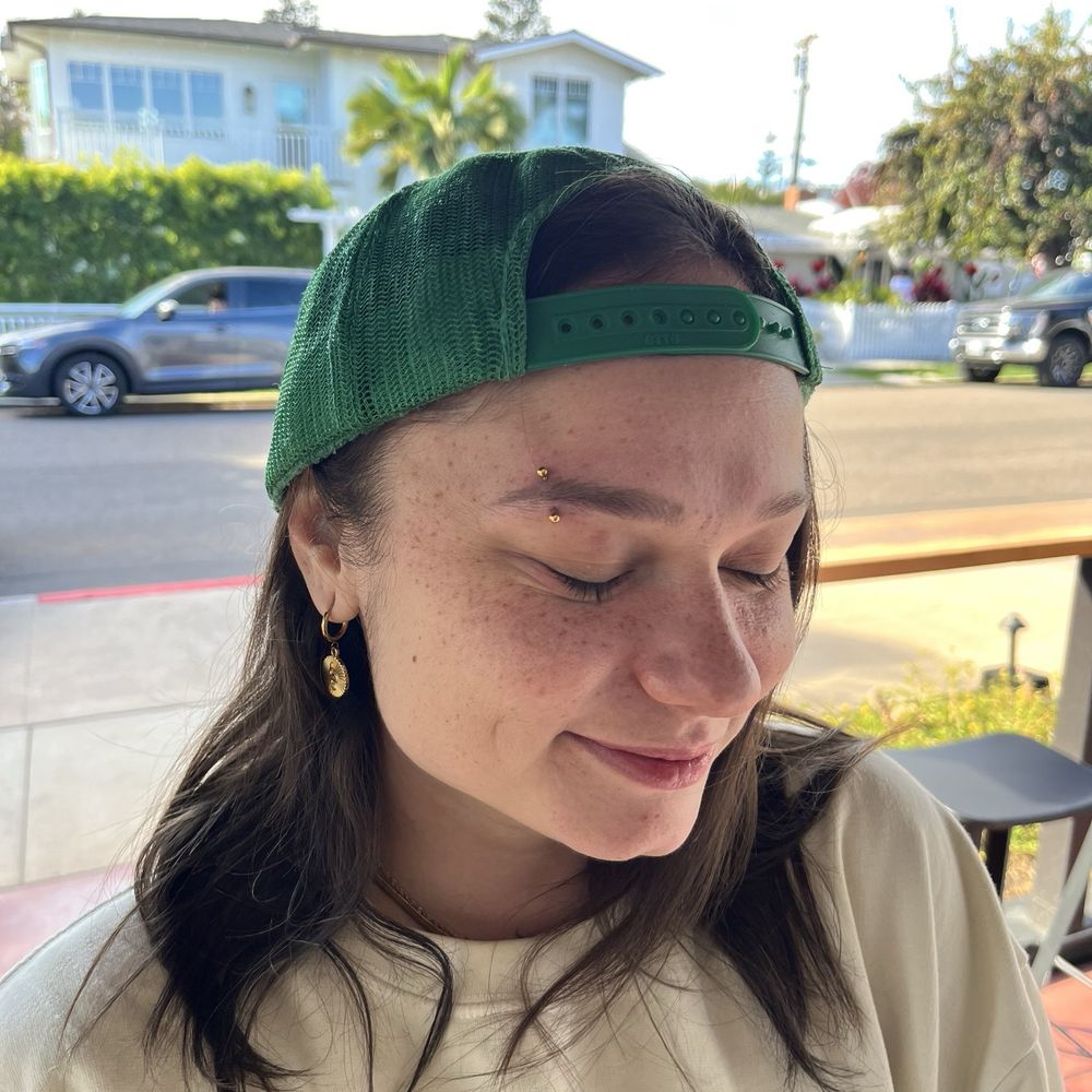 Gold curved barbell eyebrow jewelry and piercing by Devyn!