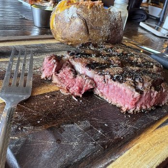 Carnivores Steakhouse - Perfectly cooked, medium rare steak. We were so excited about our food. This was the only photo! - Steakhouses Near Me - Saint Robert, Missouri