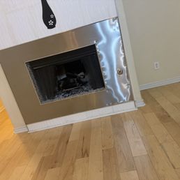 Dented fireplace surround with bad tile work above and a sticker instead of a mantle. Dented fireplace surround with bad tile work above and a sticker instead of a mantle.