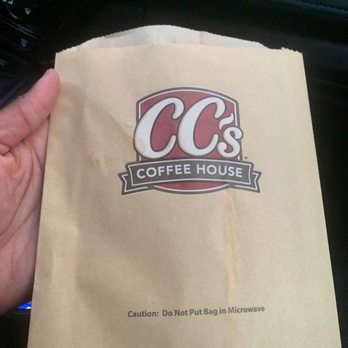 Cc's Coffee House - a hand holding a bag of coffee - Coffee & Tea Near Me - Carencro, Louisiana