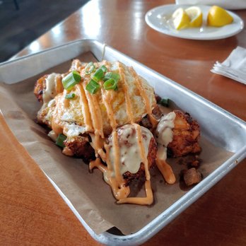 The Goat Hilliard - FARMHOUSE TOTS* Crispy tots, pork belly, fried egg, beer cheese, scallions, sriracha aioli - Bars Near Me - Hilliard, Ohio