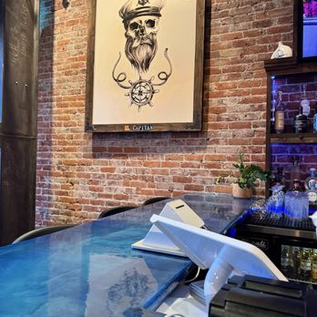 Captains Grill - Upland - Bar area with cool garage door and brick wall for industrial loft style and great dim lighting. - Seafood Near Me - Upland, California