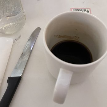 Toast Kitchen & Bar - Coffee cup with dried stain and knife with rust spots - Breakfast & Brunch Near Me - Brea, California Toast Kitchen & Bar - Coffee cup with dried stain and knife with rust spots - Breakfast & Brunch Near Me - Brea, California