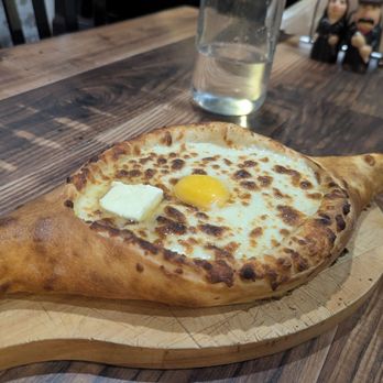Sakartvelo - Ajaruli Khachapuri - cheese bread boat with egg and butter - Georgian Near Me - Philadelphia, Pennsylvania Sakartvelo - Ajaruli Khachapuri - cheese bread boat with egg and butter - Georgian Near Me - Philadelphia, Pennsylvania