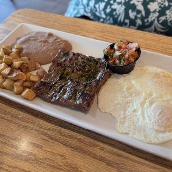 La Cocina de Roberto - STEAK AND EGGS: Grilled steak topped chimichurri with two eggs. Served with a side of breakfast potatoes, refried beans, and tortillas. - Mexican Near Me - The Woodlands, Texas La Cocina de Roberto - STEAK AND EGGS: Grilled steak topped chimichurri with two eggs. Served with a side of breakfast potatoes, refried beans, and tortillas. - Mexican Near Me - The Woodlands, Texas