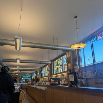 Dusty Groove - A record store interior features wooden display cases filled with vinyl records, large windows allowing natural light, and modern ceiling lighting. - Music & DVDs Near Me - Chicago, Illinois