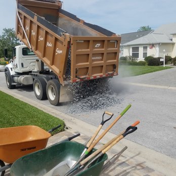 Sharp Lawn & Landscape - a dump truck dumping gravel into a wheelbarrow - Landscaping Near Me - The Villages, Florida Sharp Lawn & Landscape - a dump truck dumping gravel into a wheelbarrow - Landscaping Near Me - The Villages, Florida
