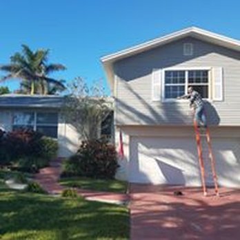 Window Pane Solutions - a man on a ladder in front of a house - Windows Installation Near Me - Saint Petersburg, Florida Window Pane Solutions - a man on a ladder in front of a house - Windows Installation Near Me - Saint Petersburg, Florida