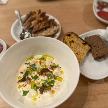 Caviste - a bowl of soup and bread on a table - Wine Bars Near Me - Winston Salem, North Carolina