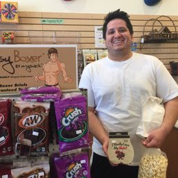 a man standing in a store holding a bag of popcorn a man standing in a store holding a bag of popcorn