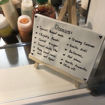 imPerfect Fresh Eats - Dressing list - A small whiteboard with handwritten dressings list at imPerfect Fresh Eats, featuring options like Caesar, peanut sauce, and garlic aioli. - Acai Bowls Near Me - Toronto, Ontario