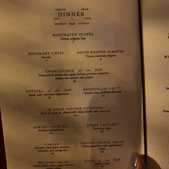 Ash Bar - A dinner menu featuring dishes like marinated olives, house roasted almonds, charcuterie, oysters, and more, with prices listed. The menu is printed on cream-colored paper. - Cocktail Bars Near Me - Baltimore, Maryland