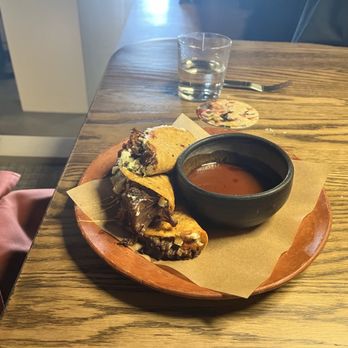 Amano - Tacos de Birria! Marinated beef tacos with melted cheese and herbs with marinade broth and spices and herbs. A hint of lime! - Cocktail Bars Near Me - Caldwell, Idaho