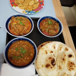 Vegetable rice, curry chicken on left, curry goat on right, chick peas and naan breads. Yum! Vegetable rice, curry chicken on left, curry goat on right, chick peas and naan breads. Yum!