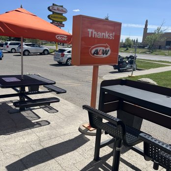 A&W - a parking lot with tables and umbrellas - Fast Food Near Me - Calgary, Alberta
