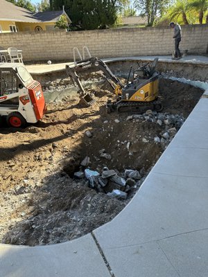 This backyard remodel project began with the demolition and removal of an old in-ground pool to create a new functional outdoor space. - Pool demolition and backyard concrete preparation project completed with excavation, grading, compaction, and site cleanup to prepare for a new outdoor living area