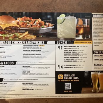 Buffalo Wild Wings - Menu - Buffalo Wild Wings menu includes sections for hand-breaded chicken sandwiches, wraps, tacos, and drinks. The menu lists various chicken sandwich options, wraps with different fillings, and tacos with toppings. Drink options include sodas, alcoholic beverages, and desserts like chocolate fudge cake and ice cream. Calorie counts are provided for each item, and some dishes are marked as top picks or served with sides like fries and drinks. The menu is designed for dine-in service, with options for sharing and customization. - Sports Bars Near Me - Springfield, Oregon