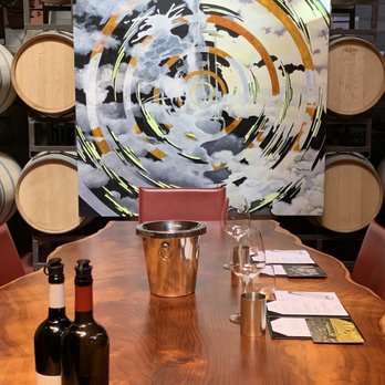 Chappellet - a wooden table with wine glasses and bottles - Wineries Near Me - Saint Helena, California Chappellet - a wooden table with wine glasses and bottles - Wineries Near Me - Saint Helena, California