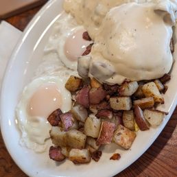 Biscuit and gravy with steamed eggs and home potatoes.