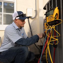 AC/DC Air Conditioning - Our skilled HVAC technician performing a professional air conditioning repair, ensuring your home stays cool and comfortable.