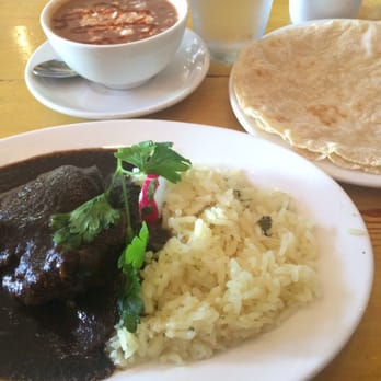 La Carta de Oaxaca - Mole negro with pork and rice with a side of pinto beans. - Mexican Near Me - Seattle, Washington La Carta de Oaxaca - Mole negro with pork and rice with a side of pinto beans. - Mexican Near Me - Seattle, Washington
