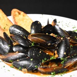 TWIST by Heidy - MUSSELS AL FUEGO. Steamed Mussels bathed in coconut tequila broth, infused with chili, fresh cilantro and smoky chorizo