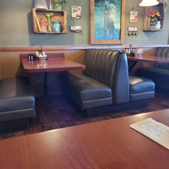 Perkos Restaurant - Booth - Interior of a retro diner with booth seating, wall decorations including shelves, signs, and a water fountain picture, and hanging pendant lights. - Diners Near Me - Modesto, California