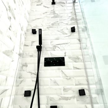GS Builds - a shower in a bathroom with a white marble wall - Flooring Near Me GS Builds - a shower in a bathroom with a white marble wall - Flooring Near Me