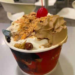 a cup of ice cream with a cherry on top a cup of ice cream with a cherry on top