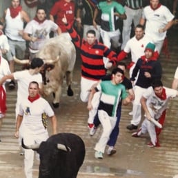 a group of men running with bulls
