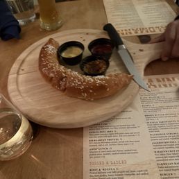 Half eaten pretzel with 3 mustards, full pint beer Half eaten pretzel with 3 mustards, full pint beer