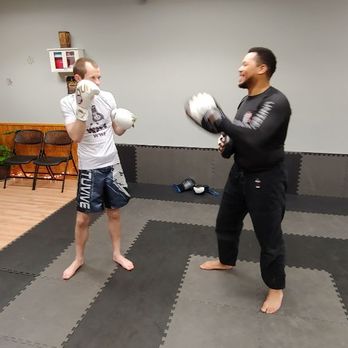 United Jiu Jitsu - Student and Coach Riser practicing strikes in UJJ's Adult Kickboxing Class. - Kickboxing Near Me - Maplewood, Minnesota