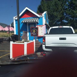 a white truck parked in front of a blue and red building a white truck parked in front of a blue and red building