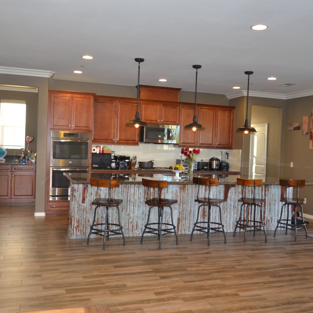 Albert Sanchez Construction - Albert did custom metalwork under kitchen island, three hanging lights, crown molding, paint, and staining of arm for stairs on left - General Contractors Near Me - San Bernardino, California