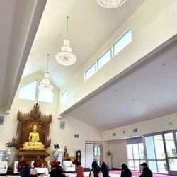 Burma Buddhist Temple - Buddhist prayer hall,  golden Buddha statue, guests and monks in meditation and reflection.