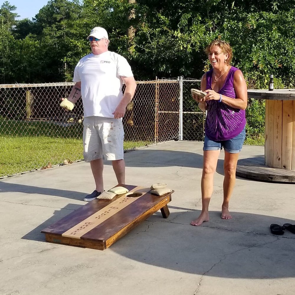 The Hidden Tavern - a man and a woman playing corn hole - Bars Near Me - Lexington, South Carolina The Hidden Tavern - a man and a woman playing corn hole - Bars Near Me - Lexington, South Carolina