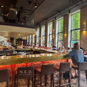 Sava's - A restaurant interior featuring large windows, a bar with bottles, and patrons seated at tables and bar stools. - Bars Near Me - Ann Arbor, Michigan