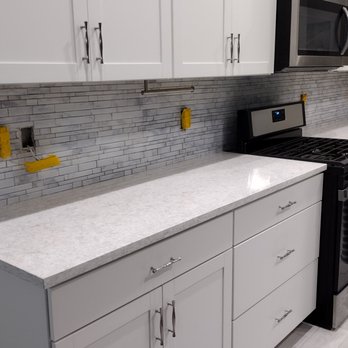 PvBowes - a kitchen with white cabinets and a black stove - General Contractors Near Me PvBowes - a kitchen with white cabinets and a black stove - General Contractors Near Me
