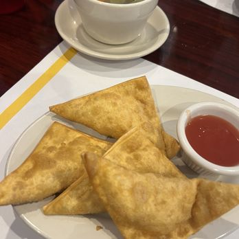 Cam Ranh Bay - Cheese wontons - Fried wontons served with a side of red dipping sauce and a bowl of clear soup with vegetables on a restaurant table. - Vietnamese Near Me - Eagan, Minnesota
