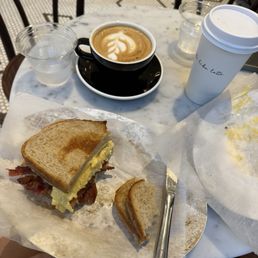 Breakfast sandwich with scrambled eggs and a Flat White Breakfast sandwich with scrambled eggs and a Flat White