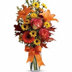 Rexburg Floral Shop - A burst of beauteous blooms in autumn shades of orange and yellow is mixed with a handful of oak leaves.