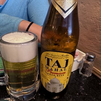 Udupi Palace - a woman sitting at a table with a beer - Indian Near Me - Berkeley, California