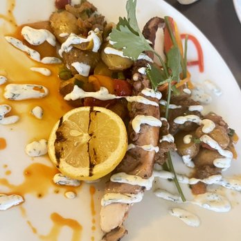 El Quenepo - Seared Octopus chorizo and fingerling potato hash, cilantro lime sour cream, charred lemon - Caribbean Near Me - Vieques, Puerto Rico