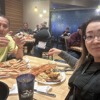 Tradewinds Buffet - A woman and a man are seated at a table in a restaurant, enjoying a seafood buffet with crab legs, shrimp, and fried foods. - Buffets Near Me - Welch, Minnesota