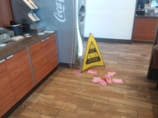 Photo of Wendy's - Kansas City, MO, US. Mess directly in front of the soft drink fountain.  They didn't even bother to clean it up, just put the sign out and create a slip hazard.