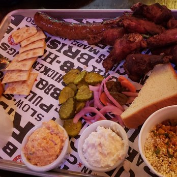 Bub City - 3 meat combo ($33). CW from top: hot link, 8pc smoked wings, mexican elote, coleslaw, pimento cheese, pit beans, corn muffin, sweet pickles - Bars Near Me - Rosemont, Illinois Bub City - 3 meat combo ($33). CW from top: hot link, 8pc smoked wings, mexican elote, coleslaw, pimento cheese, pit beans, corn muffin, sweet pickles - Bars Near Me - Rosemont, Illinois