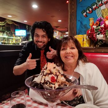 Buca di Beppo Italian Restaurant - Delita being encouraged with her birthday sundae by our server Nico - Italian Near Me - Brea, California Buca di Beppo Italian Restaurant - Delita being encouraged with her birthday sundae by our server Nico - Italian Near Me - Brea, California