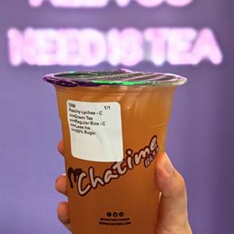 a hand holding a cup of iced tea